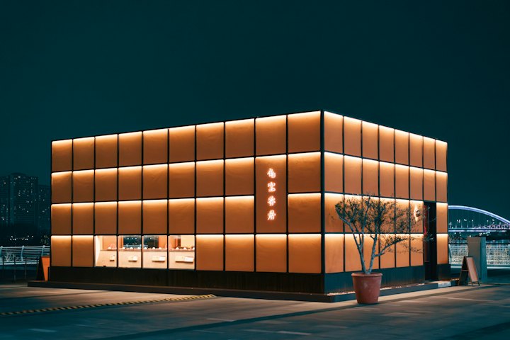 Modern commercial building lit at dusk